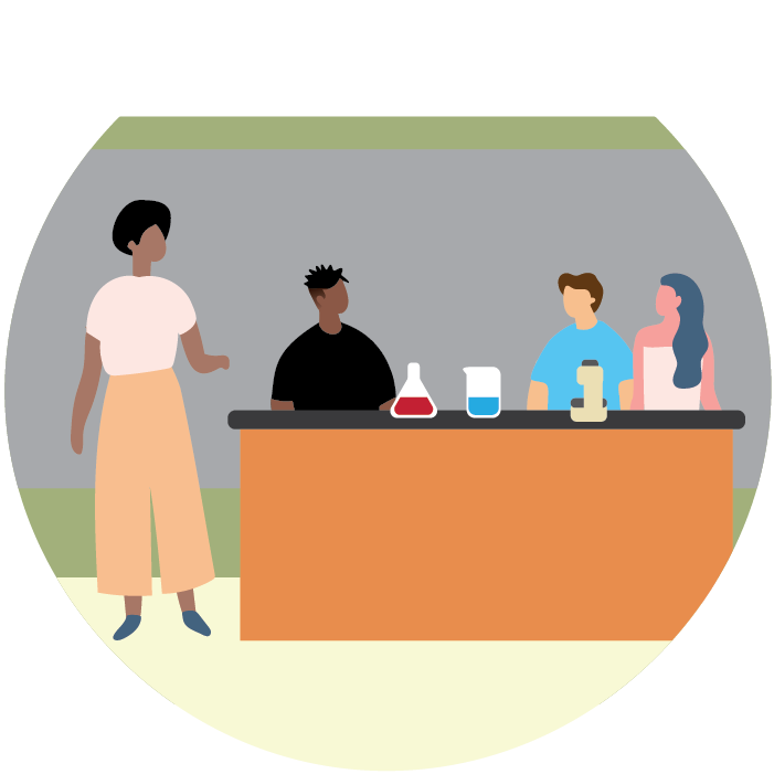 Teacher standing next to a group of students who are sitting at a table in a science classroom.